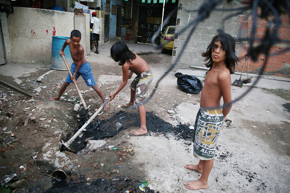 Chidren attempting to unclog a sewer in Rio de Janeiro. Open sewage like this could spread typhoid. Chidren attempting to unclog a sewer in Rio de Janeiro. Open sewage like this could spread typhoid.