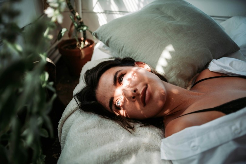 girl lying on bed sunlight on her face