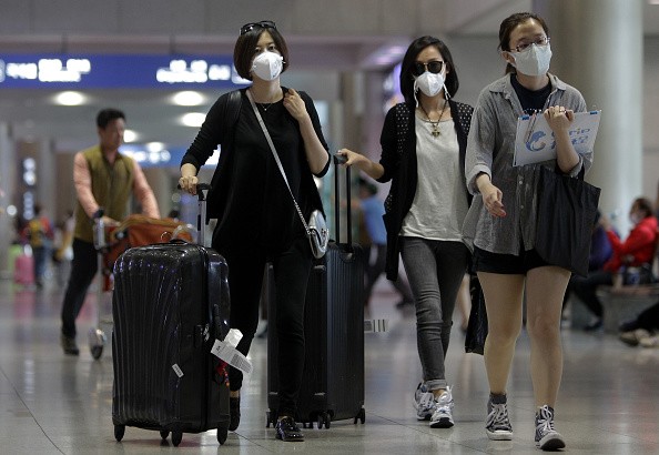 Travelers wearing masks because of the MERS outbreak as they walk though a South Korean airport. 