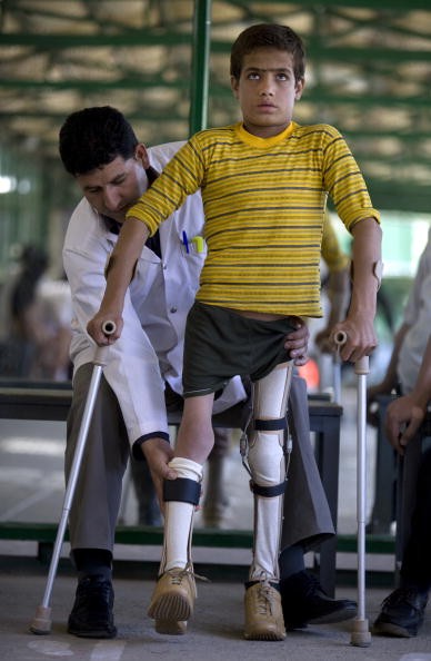 An Afghan boy who had polio is fitted with new braces for his legs. Low rates of polio vaccination in the United States could bring the disease back. 
