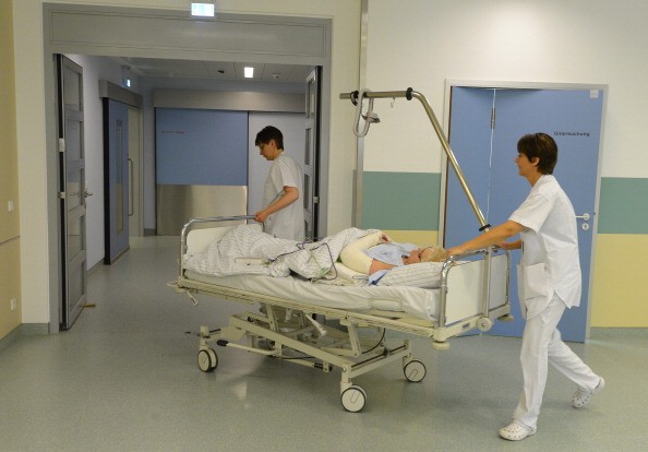 Nurses moving a patient and bed through a hospital. A study of nurses found an association between working long hours and having difficulty becoming pregnant.