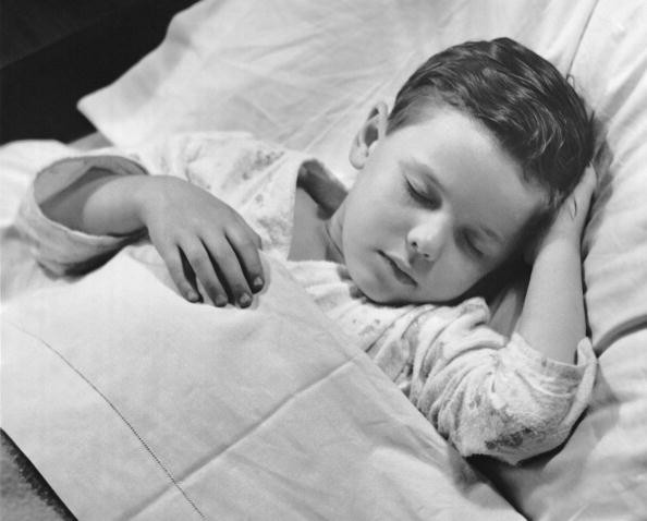 Young boy asleep in bed