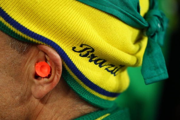 A fan at a Brazilian soccer match wears earplugs to protect from the noise of the stadium. A noisy environment may be linked to increased risk of heart disease.  
