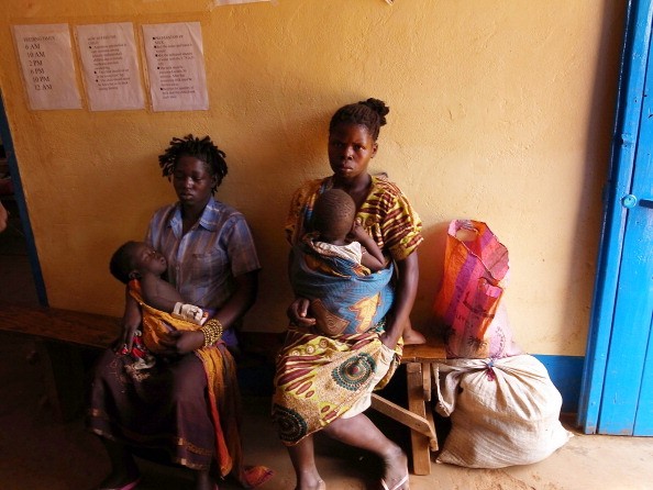 A mother and her children in Sudan await treatment for malaria.