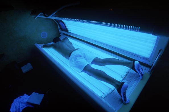 A young man on a tanning bed. The FDA is proposing a ban on the use of tanning beds by children and teens. 