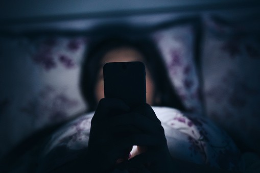 Girl Using Phone in Bed in the Dark