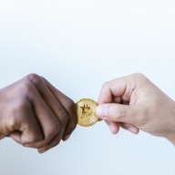 Close-Up Shot of Two People Holding a Gold Coin