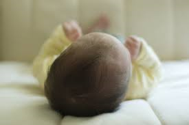 Babies should be put to sleep on their backs in a warm sleep outfit, with nothing else in the crib with them.