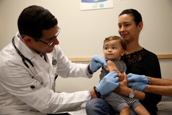 A pediatrician administering a measles vaccine. 
